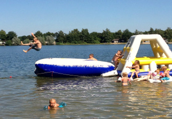 Kinder spielen auf aufblasbaren Wasserstrukturen im Holiday Park „Tolplas 19“ in den Niederlanden.