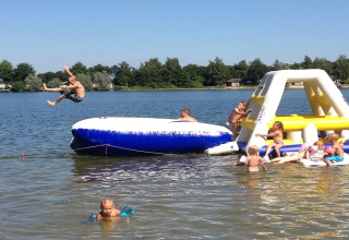 Kinderen spelen op opblaasbaar waterspeelgoed bij Holiday park «Tolplas 19» in Nederland.