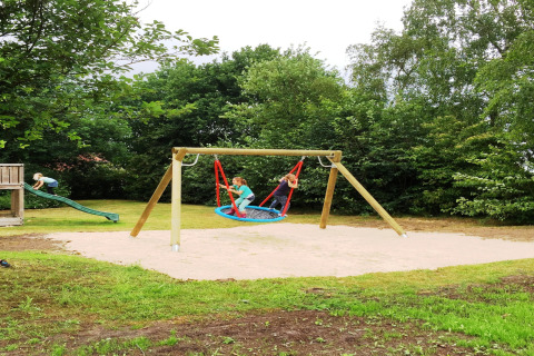 Børn leger på en legeplads ved Holiday park Tolplas 19, med gynger og rutsjebane i Holland.