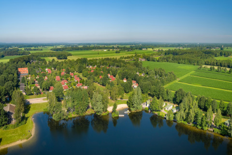 Vista aerea di una tiny house al Holiday park Tolplas 19 nei Paesi Bassi, immersa nel verde e vicino all'acqua.