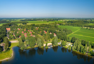 Vista aérea de una tiny house en Holiday park Tolplas 19 en los Países Bajos, rodeada de naturaleza y agua.