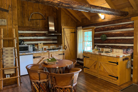 Rustikale Küche in einer amerikanischen Blockhütte mit Holzmöbeln, fotografiert in den Niederlanden.