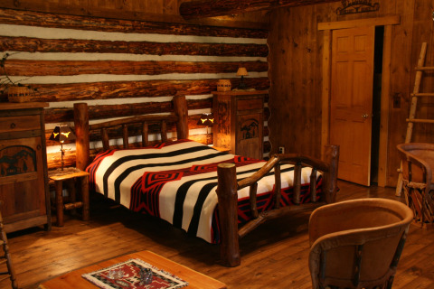 Chambre chaleureuse dans le chalet American Log Cabin aux Pays-Bas, décorée de meubles rustiques en bois.