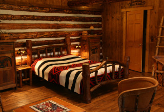 Hyggeligt værelse i American Log Cabin chalet i Holland, indrettet med træmøbler og et rustikt interiør.