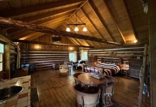 Interno di uno chalet di tronchi accogliente nei Paesi Bassi con arredi in legno e decorazioni rustiche.
