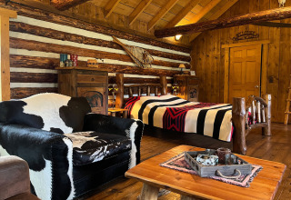 Gemütliches Inneres einer American Log Cabin im Chalet-Stil in den Niederlanden mit Holz und Kuhfell.