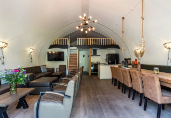 Moderne Lodge-Wohnzimmer mit gewölbter Decke, Essbereich, Sitzecke und Küche in Residence De Eese.