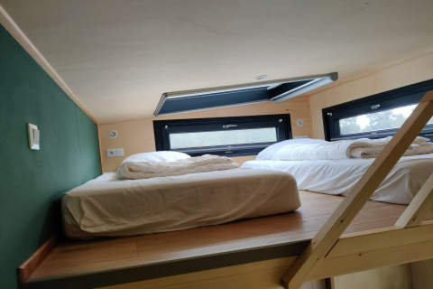 Loft bedroom with two beds and skylight in a Tiny House for 2 persons, located in the Netherlands.