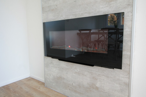 Moderne elektrische haard aan een lichte wand, weerspiegelt eetkamer in Residence de Eese 20, Nederland.