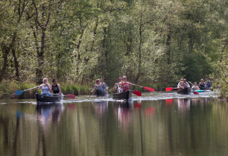 Des personnes pagayant en canoë sur une rivière paisible entourée de nature près du Tiny House for 2 aux Pays-Bas.