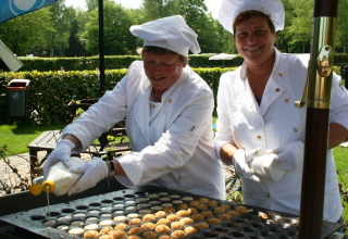 Twee koks bereiden traditionele Hollandse poffertjes buiten bij Residence de Eese 20 in Nederland.
