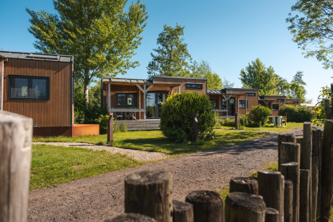Modernas tiny houses para 2 personas rodeadas de vegetación en un parque vacacional en los Países Bajos.