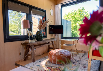 Gezellige woonkamer van een tiny house voor twee personen in Nederland met veel licht en moderne inrichting.