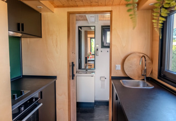 Compacte keuken en badkamer in een tiny house voor twee personen in Nederland, modern ingericht.