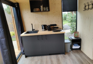 Kitchenette moderne dans la Wetland Cabin pour 2 personnes au Boetiekpark de Kas, Scherpenzeel, Friesland, Pays-Bas.