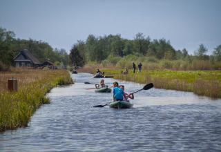 People kayaking near Wetland Cabin for 2 at Boetiekpark de Kas, Scherpenzeel, Friesland, Netherlands.