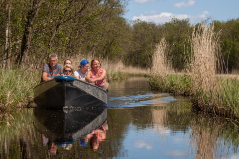 Un gruppo di persone in barca su un canale circondato dalla natura vicino alla lodge Large Green House nei Paesi Bassi.