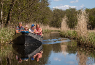 Un gruppo di persone in barca su un canale circondato dalla natura vicino alla lodge Large Green House nei Paesi Bassi.