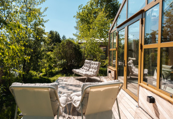 Zonnig terras van de Large Green House lodge voor 4 personen in Nederland, met veel groen rondom.