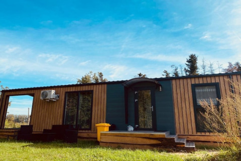 Holiday home Inselblick chalet in Nowe Warpno, featuring wooden facade, steps, and outdoor seating area.