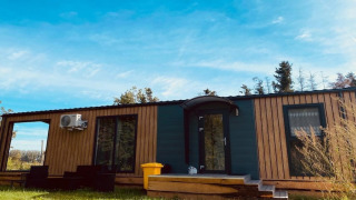Chalet Holiday home Inselblick en Nowe Warpno con fachada de madera, escalones y zona de descanso exterior.