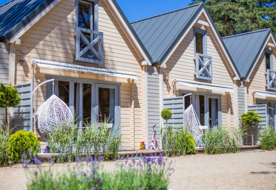 Bright holiday cottage for 5 in Pobierowo, featuring hanging chairs, garden, and a warm, modern facade.