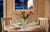 Mesa redonda preparada para cuatro con tulipanes en un jarrón, en Aquarius Cottages, Alemania.