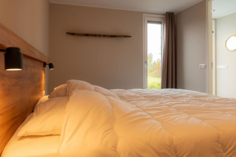 Camera accogliente con letto morbido e luce naturale al lodge Op'e Pleats 1 nei Paesi Bassi.