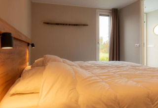Camera accogliente con letto morbido e luce naturale al lodge Op'e Pleats 1 nei Paesi Bassi.