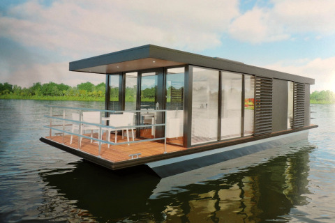 Das moderne Hausboot Refugio fährt auf dem Wasser, umgeben von grüner Natur und einem offenen Deck.