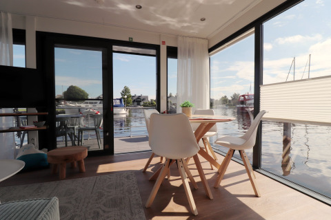 Indvendig udsigt fra Houseboat 'Refugio' ved vandet i Nederlandene, med moderne spiseplads.