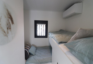 Dormitorio acogedor con literas dentro de la casa flotante Refugio situada en los Países Bajos.