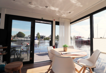 Helles, modernes Wohnzimmer auf Hausboot „Refugio“ mit Blick auf Wasser und Boote, Niederlande.