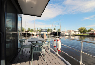 Vue depuis la terrasse de Houseboat Refugio avec table, chaises et marina aux Pays-Bas