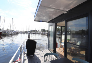 Udsigt fra dækket af husbåden Refugio i Holland, med både i marinaen og moderne interiør.