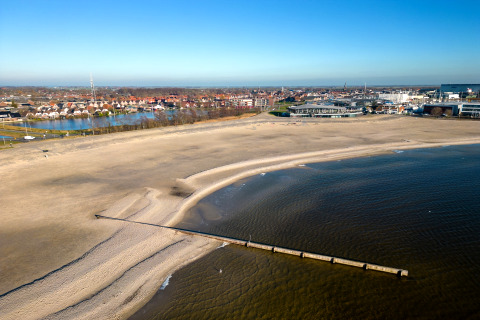 Udsigt over stranden og havet taget fra Houseboat «Refugio» i Holland med huse og by i baggrunden.
