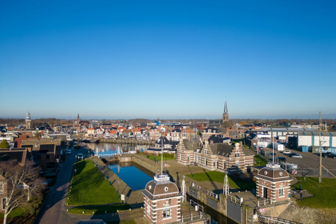 Blick von Hausboot Refugio auf eine niederländische Stadt mit Kanälen, Brücke und historischen Gebäuden.