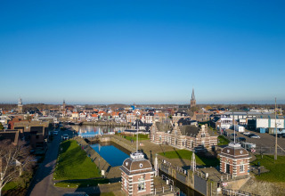Vue depuis la Houseboat Refugio aux Pays-Bas, montrant un canal, une écluse et des bâtiments historiques en ville.