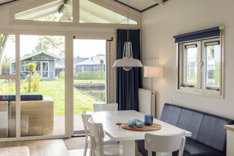 Helle, moderne Essecke im Chalet des Water park „Terkaple 2“ in den Niederlanden mit Gartenblick.