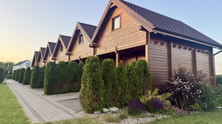 Two-storey holiday cottages for up to 6 people in Mielenko, with green hedges and paved pathways.