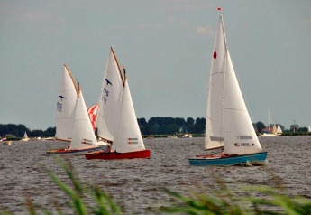 Sailboats on the lake at Water park «Terkaple 1» in the Netherlands, surrounded by lush greenery.