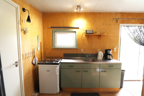 Petite cuisine chaleureuse dans Cosy cabin 1 aux Pays-Bas avec réfrigérateur, évier et cafetière.