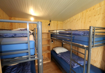 Vue intérieure d’un dortoir du Cosy cabin 1, quatre lits superposés, murs en bois, Pays-Bas.