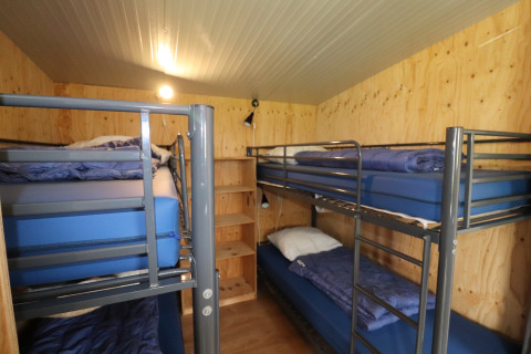 Vue intérieure d’un dortoir du Cosy cabin 1, quatre lits superposés, murs en bois, Pays-Bas.