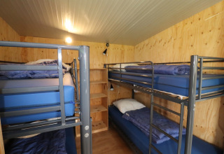 Vue intérieure d’un dortoir du Cosy cabin 1, quatre lits superposés, murs en bois, Pays-Bas.