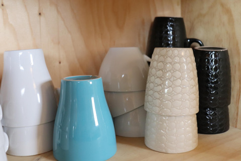 Tasses en céramique de différentes couleurs et textures empilées sur une étagère en bois, Cosy cabin 1, Pays-Bas.