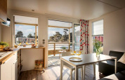 Lichte woonkamer in het Terrace Lodge 2 chalet in Nederland, met uitzicht op terras en natuur.