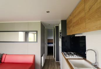 Modern chaletinterieur in Terrace Lodge 2, Nederland, met woonkamer, keuken en zicht op slaapkamer.