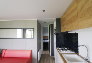 Modern chalet interior at Terrace Lodge 2 in the Netherlands, featuring living room, kitchen and bedroom view.