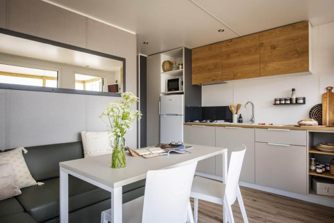 Modern kitchen and dining area in Terrace Lodge 2 chalet in the Netherlands, bright with wood accents.